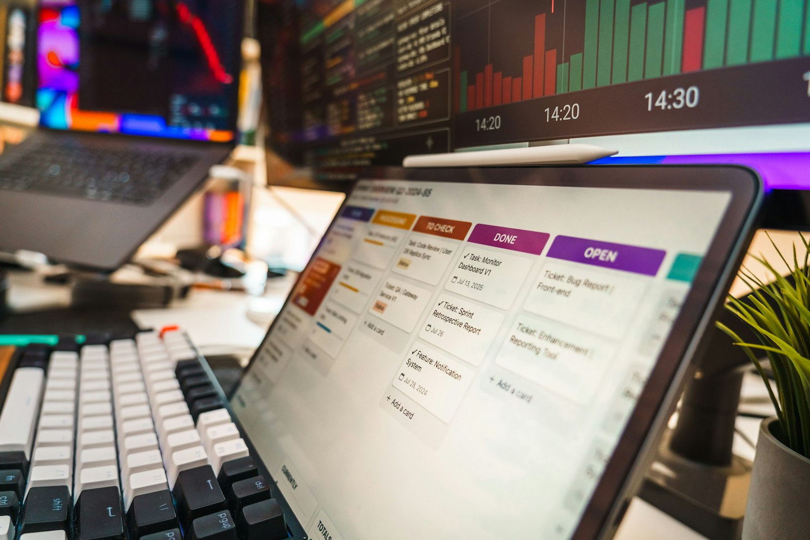 A tablet displaying a project management board with task cards on a desk